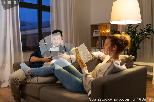 Image of couple with tablet computer and book at home