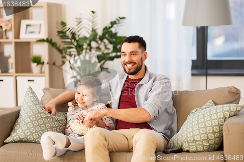 Image of happy father and daughter watching tv at home