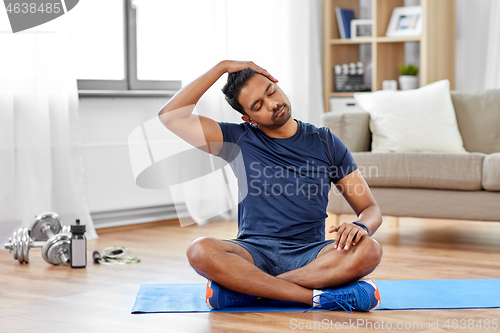 Image of man training and stretching body at home