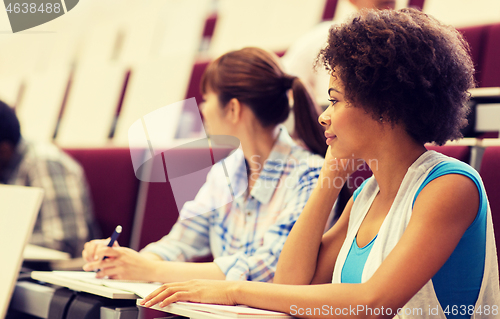 Image of group of students talking in lecture hall