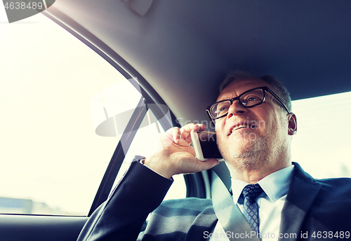 Image of senior businessman calling on smartphone in car