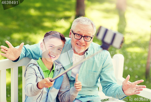 Image of old man and boy taking selfie by smartphone