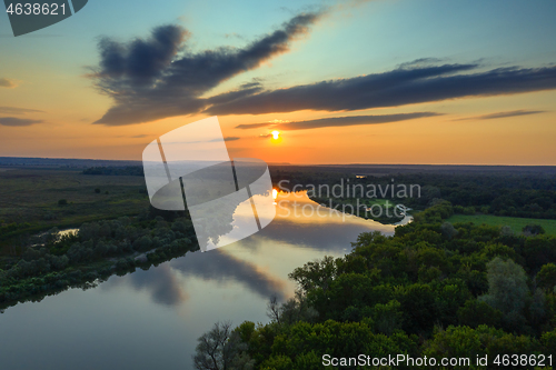 Image of sunrise or sunset with forest and river