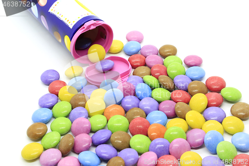 Image of Multicolored glazed chocolate candies out of the container