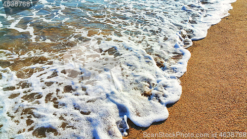 Image of Sea water with white foam in the coastal sand