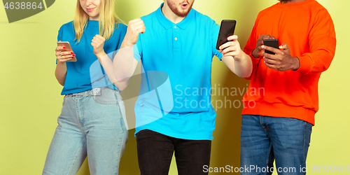 Image of Group of friends using mobile smartphones. Teenagers addiction to new technology trends. Close up.