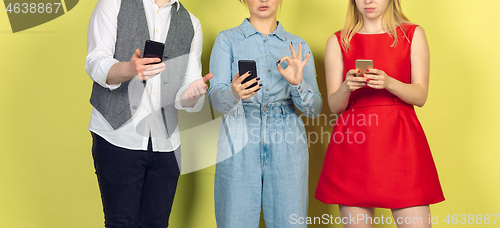 Image of Group of friends using mobile smartphones. Teenagers addiction to new technology trends. Close up.