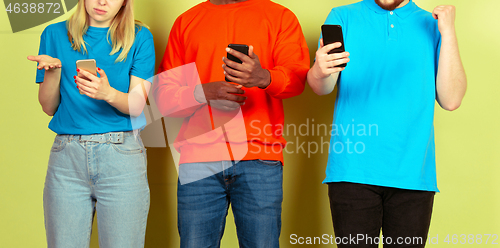 Image of Group of friends using mobile smartphones. Teenagers addiction to new technology trends. Close up.