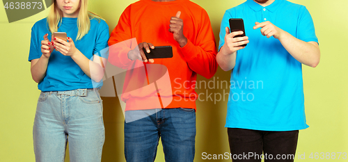 Image of Group of friends using mobile smartphones. Teenagers addiction to new technology trends. Close up.