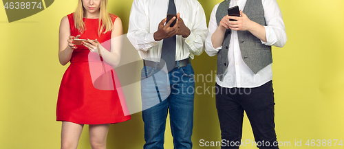 Image of Group of friends using mobile smartphones. Teenagers addiction to new technology trends. Close up.