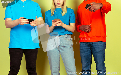 Image of Group of friends using mobile smartphones. Teenagers addiction to new technology trends. Close up.