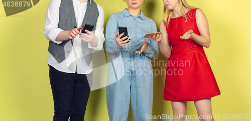 Image of Group of friends using mobile smartphones. Teenagers addiction to new technology trends. Close up.