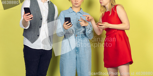 Image of Group of friends using mobile smartphones. Teenagers addiction to new technology trends. Close up.