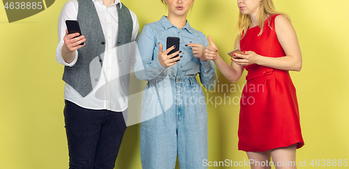 Image of Group of friends using mobile smartphones. Teenagers addiction to new technology trends. Close up.