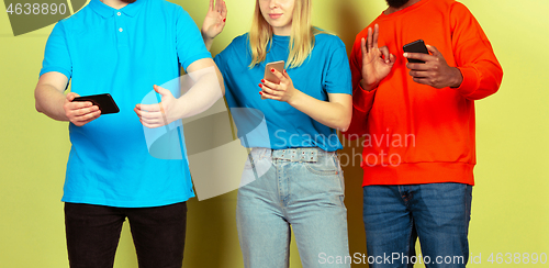 Image of Group of friends using mobile smartphones. Teenagers addiction to new technology trends. Close up.