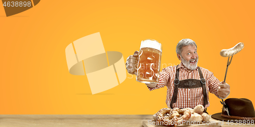 Image of Smiling senior man with beer dressed in traditional Austrian or Bavarian costume holding mug of beer at pub or studio. The celebration, oktoberfest, festival