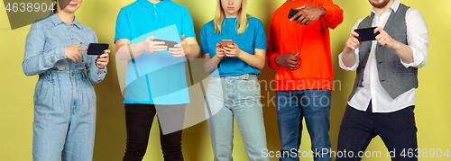 Image of Group of friends using mobile smartphones. Teenagers addiction to new technology trends. Close up.