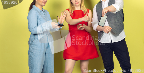 Image of Group of friends using mobile smartphones. Teenagers addiction to new technology trends. Close up.