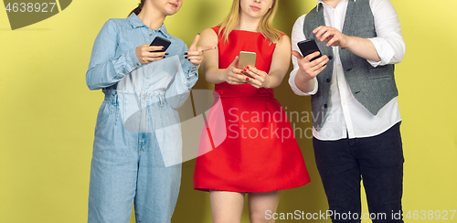 Image of Group of friends using mobile smartphones. Teenagers addiction to new technology trends. Close up.