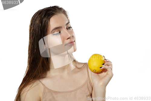 Image of Youth secrets. Beautiful young woman with lemon over white background. Cosmetics and makeup, natural and eco treatment, skin care.