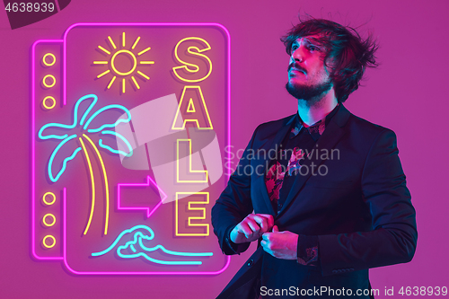 Image of Young musician, party host singing, dancing in neon light