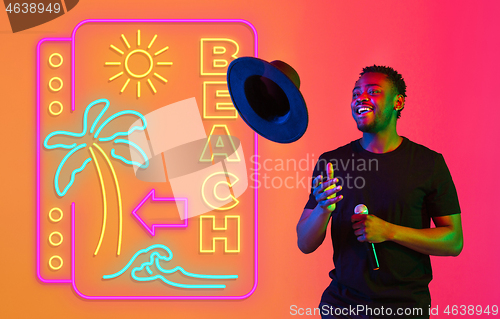 Image of Young musician, party host singing, dancing in neon light