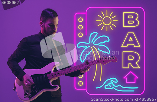 Image of Young musician playing guitar in neon light on gradient background, inspired, artwork