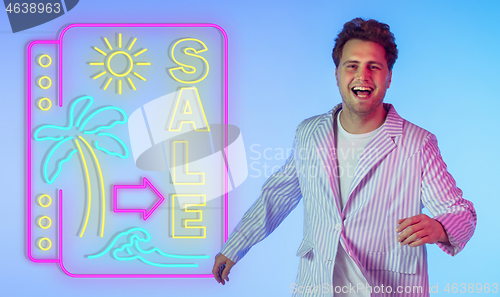 Image of Young musician, party host singing, dancing in neon light