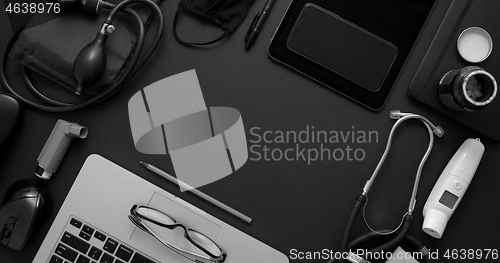 Image of Doctor desktop concept. Various medical tools and accessories placed on black background table