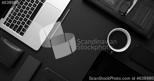 Image of Business desktop concept. Mix of office supplies and gadgets on a black table background