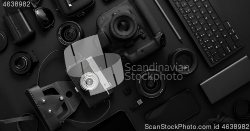 Image of hotographer workspace concept. Various digital and analog gadgets placed on black background