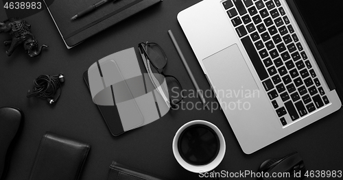 Image of Business desktop concept. Mix of office supplies and gadgets on a black table background