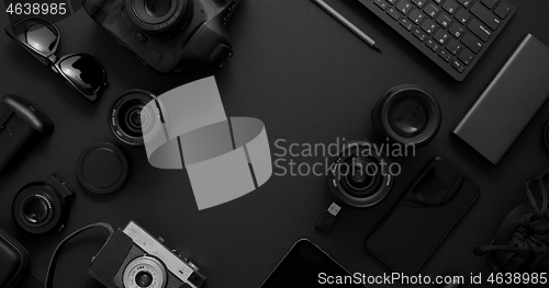 Image of hotographer workspace concept. Various digital and analog gadgets placed on black background