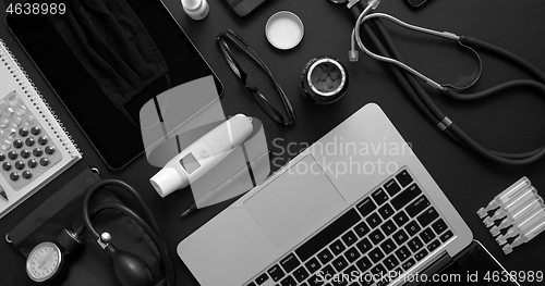 Image of Doctor desktop concept. Various medical tools and accessories placed on black background table