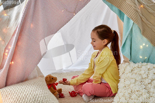 Image of girl playing tea party with teddy in kids tent