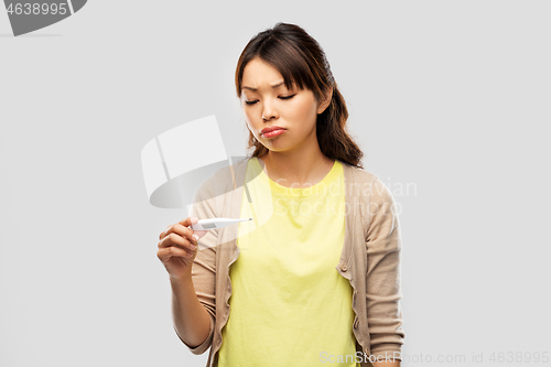 Image of sick asian woman with thermometer having fever