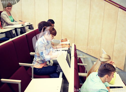 Image of group of students with notebooks at lecture hall