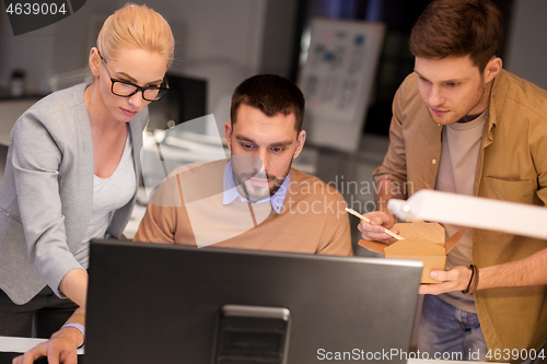 Image of business team with computer working late at office