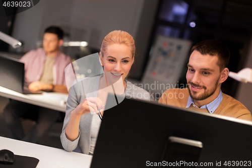 Image of business team with computer working late at office