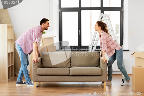 Image of happy couple moving sofa at new home