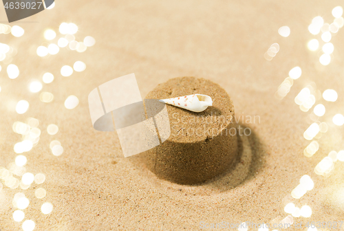 Image of sand shape made by mold with shell on summer beach