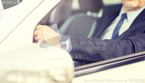 Image of senior businessman hands driving car