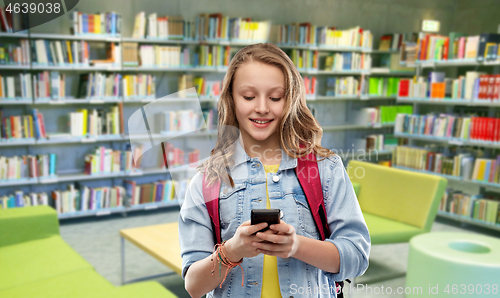 Image of teenage student girl with smartphone at library