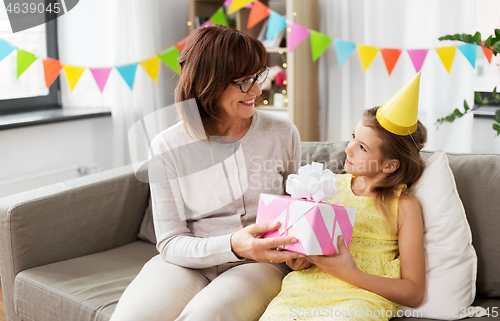 Image of grandmother giving granddaughter birthday gift