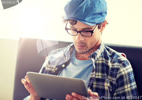 Image of man with tablet pc sitting at cafe table