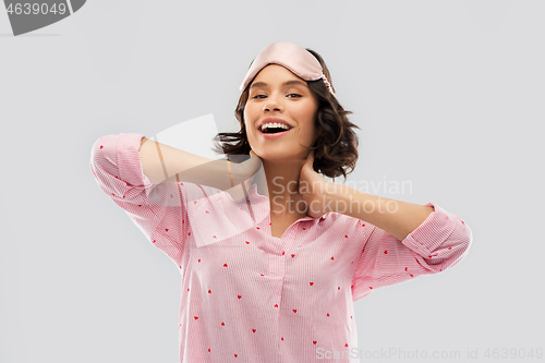 Image of happy young woman in pajama and eye sleeping mask