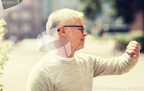 Image of senior man checking time on his wristwatch