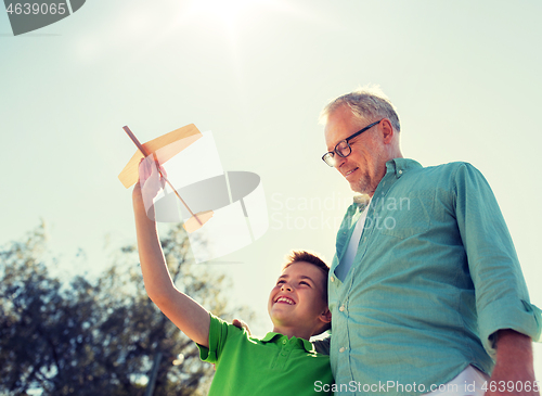 Image of senior man and boy with toy airplane over sky