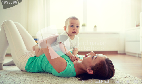 Image of happy mother playing with baby at home