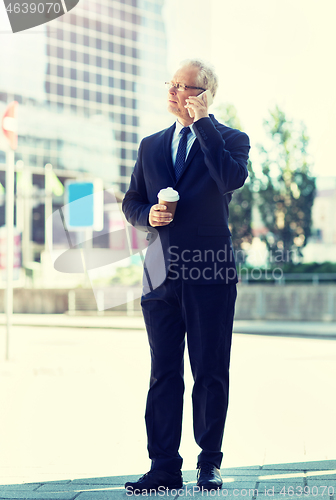 Image of senior businessman calling on smartphone in city